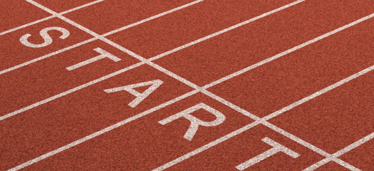 Starting line as a business symbol of the metaphore saying ready set go for the start or beginnings of a planned strategy for success as represented by a track and field stadium background as a concept of opportunity and setting goals